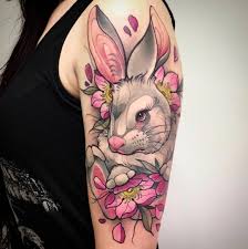 tatuaje grande de conejo con flores en el brazo